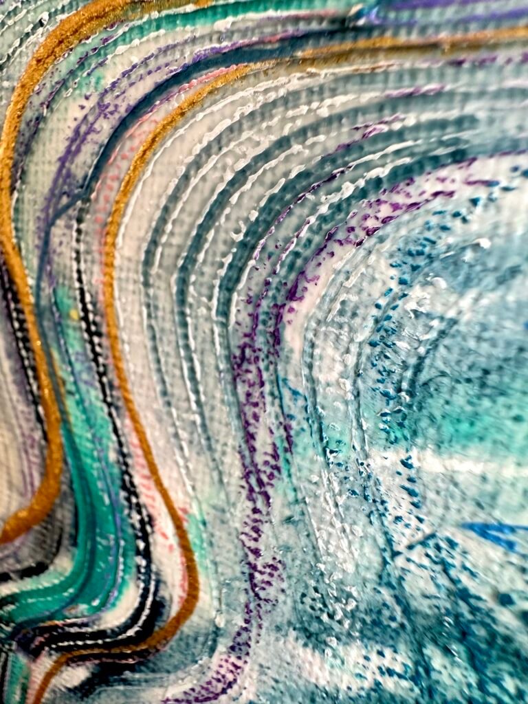 Close-up of flowing teal, white and gold painted lines on textured canvas